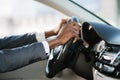 Businessman driving car on highway, holding hands on wheel