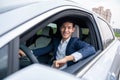 A businessman driving new electric vehicle with a happy smile. Electric car. EV Car. EV vehicle. Concept of green energy and Royalty Free Stock Photo