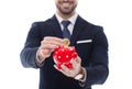 Businessman drop one bitcoin into piggy bank isolated