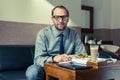 Businessman eating breakfast at home/hotel. Indoor photo.