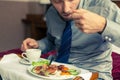 Businessman eating breakfast at home/hotel. Indoor photo.