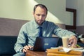 Businessman eating breakfast at home/hotel. Indoor photo. He is