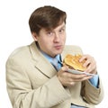 Businessman eats a sandwich isolated on a white