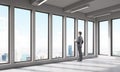 Businessman in empty room looking at big city Royalty Free Stock Photo