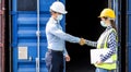 Businessman and engineer woman shake hands as hello in the container cargo harbor to loading containers.