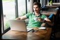 Businessman enjoying hot coffee while working online on laptop, having break during work. Royalty Free Stock Photo