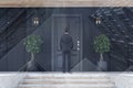 Businessman entering black door of black house Royalty Free Stock Photo