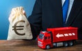 Businessman with Euro money bag and truck. High income of the transport business and the transport of goods.