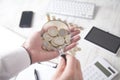 Businessman examines coins through a magnifier