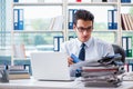 The businessman with excessive work paperwork working in office Royalty Free Stock Photo