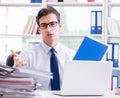 Businessman with excessive work paperwork working in office