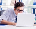 Businessman with excessive work paperwork working in office