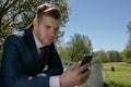 Businessman, Executive in blue suit using mobile, cell phone in the park Royalty Free Stock Photo