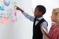 Businessman explaining to female colleague over whiteboard in office Royalty Free Stock Photo