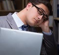 Businessman almost falling asleep working late hours in the offi
