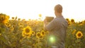 Businessman in field analyzes their income. agronomist studies crop of a sunflower. A farmer man works with a tablet in