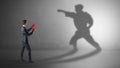 Young businessman fighting with his shadow