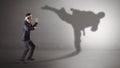 Young businessman fighting with his shadow