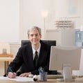 Businessman filling out paperwork at desk