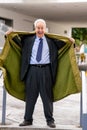 Businessman flashing open his trenchcoat to show his suit