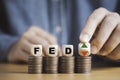 Businessman flipping up and down arrow with FED on coins stacking for Federal reserve increase and decrease interest rate control