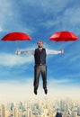 Businessman flying with umbrellas