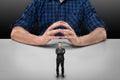Businessman with folded arms stands in front of big man sitting Royalty Free Stock Photo