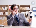 Businessman with football ball in office