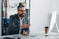 Businessman in formal wear talking in video chat in office Royalty Free Stock Photo