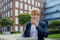 Businessman, freelancer or manager working outdoors in city park. Man with earbuds drinking coffee and listening music Royalty Free Stock Photo