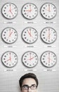 Businessman In Front Of Clocks Showing Time Across The World