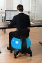 Businessman In Front Of Computer Sitting On Pilates Ball Royalty Free Stock Photo