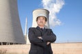 Businessman in front of cooling tower