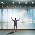 Businessman in front of office window thinking of new challenges Royalty Free Stock Photo