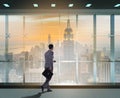 Businessman in front of office window thinking of new challenges Royalty Free Stock Photo