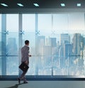 Businessman in front of office window thinking of new challenges Royalty Free Stock Photo