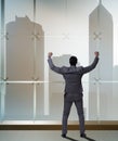 Businessman in front of office window thinking of new challenges Royalty Free Stock Photo