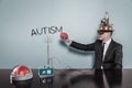 Businessman In Futuristic Helmet Holding Brain By Autism Text