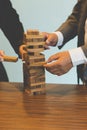 businessman gambling placing wooden block on a tower - planning, risk and strategy in business Royalty Free Stock Photo