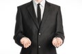 Businessman and gesture topic: a man in a black suit and tie holding two hands in front isolated on white background in studio Royalty Free Stock Photo