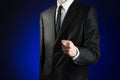 Businessman and gesture topic: a man in a black suit and white shirt showing fig hand on a dark blue background in studio isolated Royalty Free Stock Photo