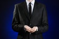 Businessman and gesture topic: a man in a black suit and white shirt showing gestures with hands on a dark blue background in stud Royalty Free Stock Photo