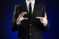 Businessman and gesture topic: a man in a black suit and white shirt showing gestures with hands on a dark blue background in stud Royalty Free Stock Photo