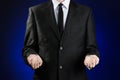 Businessman and gesture topic: a man in a black suit and white shirt showing gestures with hands on a dark blue background in stud Royalty Free Stock Photo