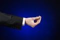 Businessman and gesture topic: a man in a black suit and white shirt showing hand gesture on an isolated dark blue background in Royalty Free Stock Photo