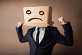 Businessman gesturing with cardboard box on his head with sad fa Royalty Free Stock Photo