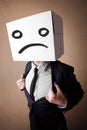 Businessman gesturing with cardboard box on his head with sad fa Royalty Free Stock Photo