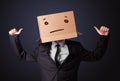 Businessman gesturing with a cardboard box on his head with straight face Royalty Free Stock Photo