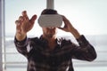 Businessman gesturing while using virtual reality headset in office Royalty Free Stock Photo