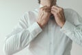 Businessman getting dressed, business person buttoning his white shirt